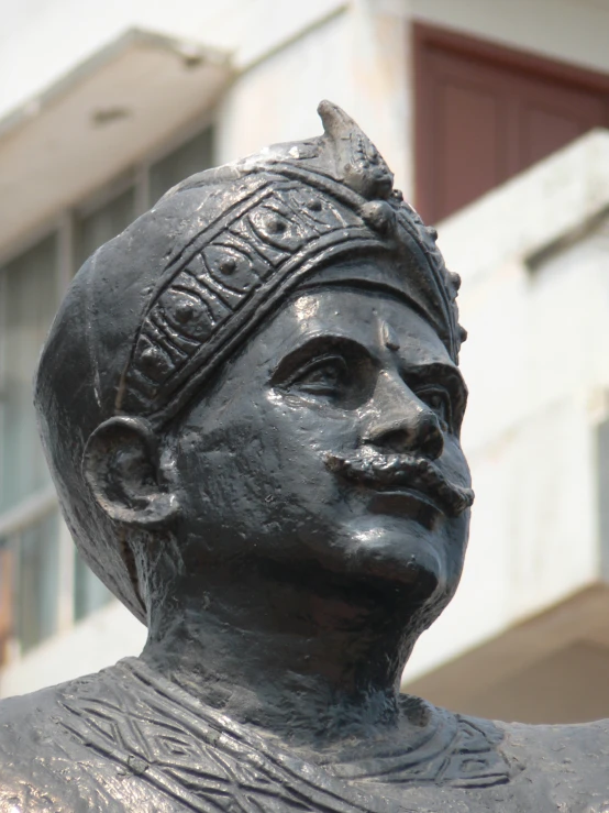 a close up view of a statue with a clock on the building behind it