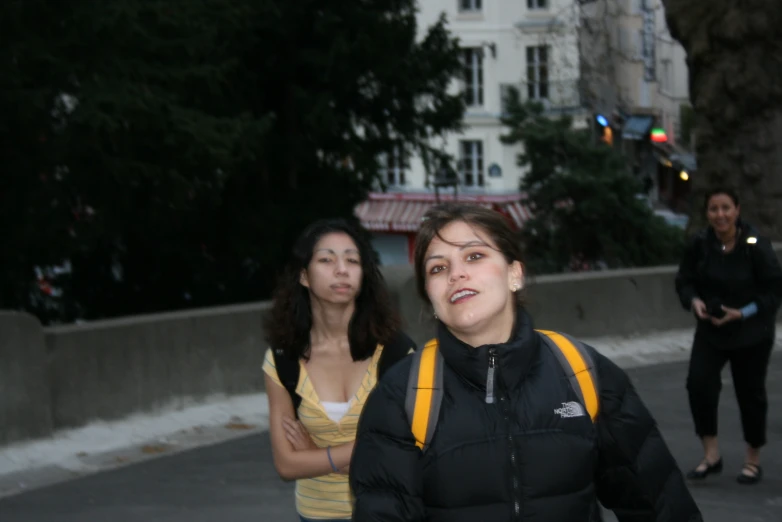 a couple of women are talking on the side walk