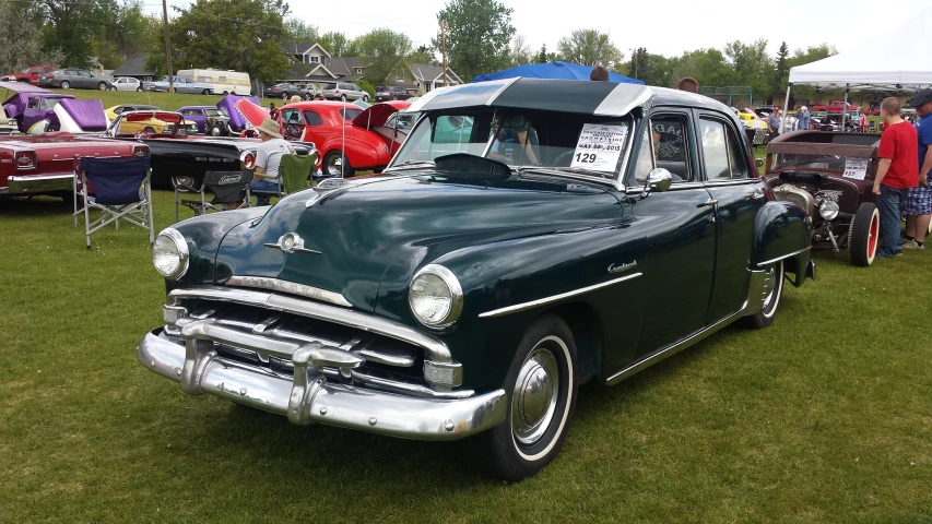 a vintage car is parked at a classic show