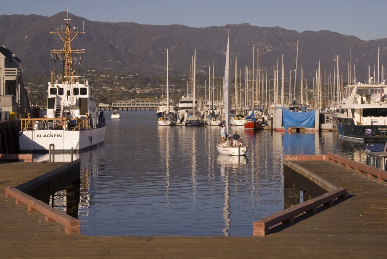 several boats are docked in the harbor by mountains