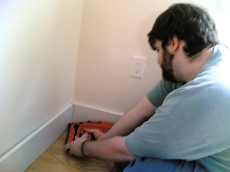 man kneeling down to fix a light switch