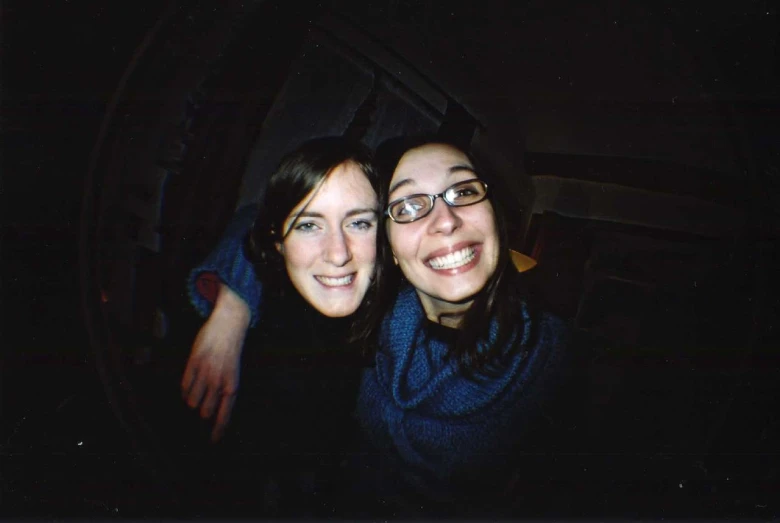 two girls are posing for the camera in the dark