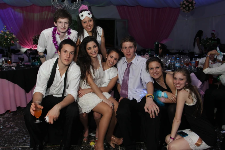 young people pose in front of a party backdrop