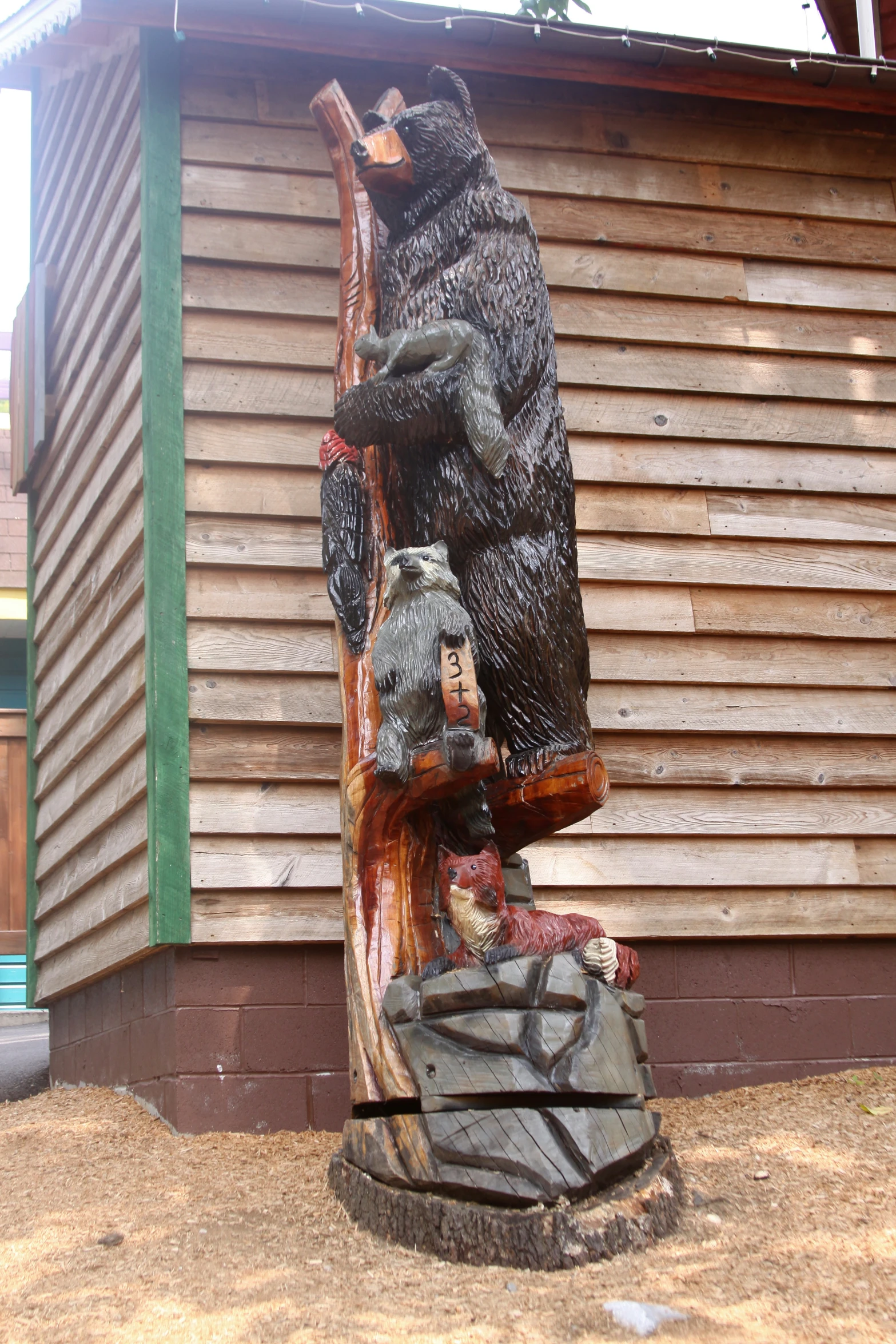 a bear sitting on a log with its mouth open