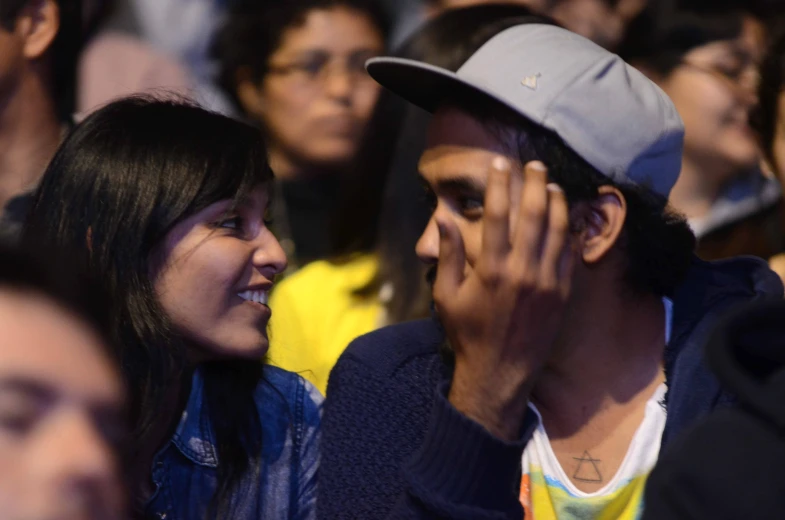 a man and woman in the audience using their cell phones