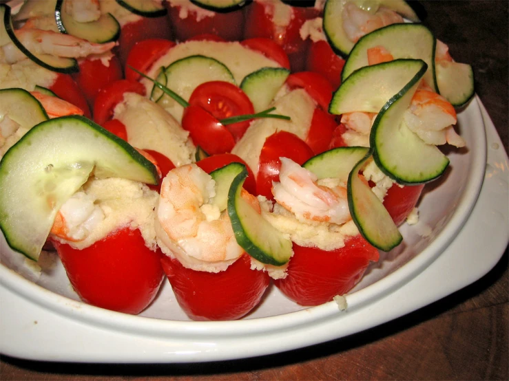 several tomatoes, cucumber and shrimps cut into small cups