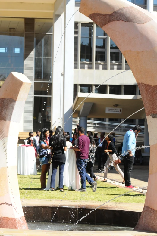 a couple of people are standing under a fountain