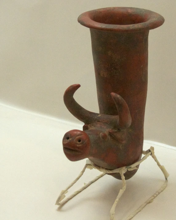 a brown vase with a spider on its side