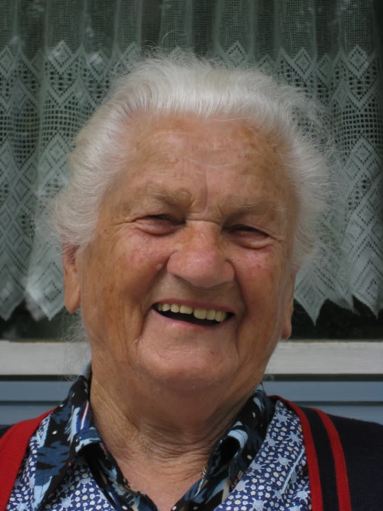 an older woman wearing an old sweater and vest