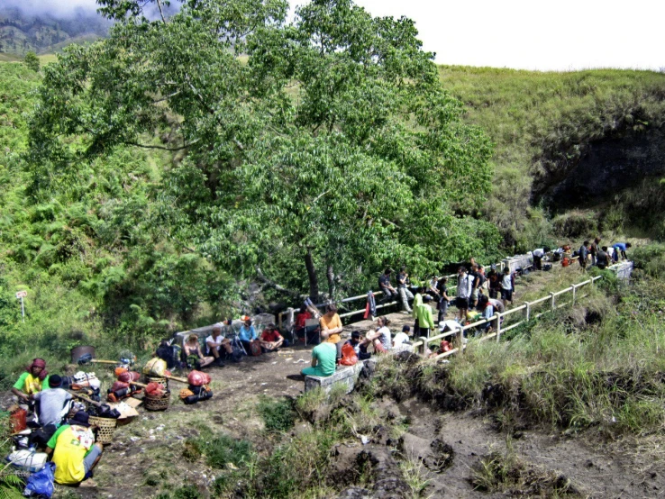 a group of people sitting on a hillside in the sun