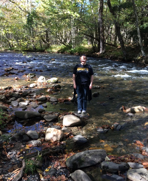 a man standing in water next to some rocks