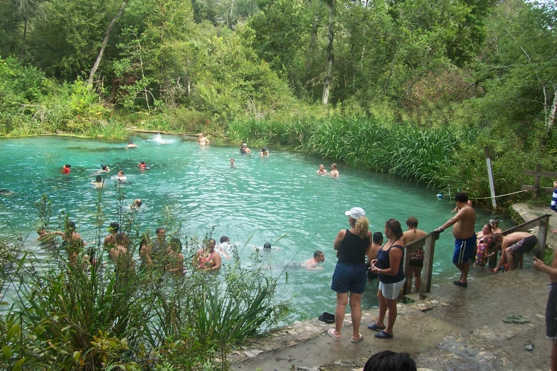 many people are standing in a pool full of water