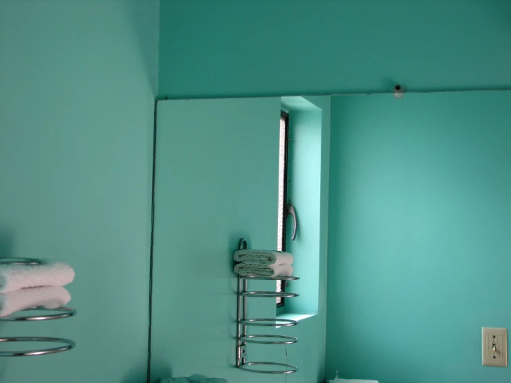 a bathroom with aqua green walls and a white toilet