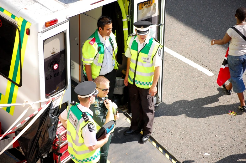 three police officers stand by the back door of an ambulance