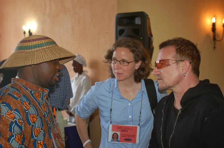 a man standing next to a woman wearing a hat