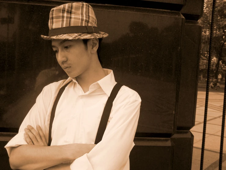 a young man is leaning against the wall