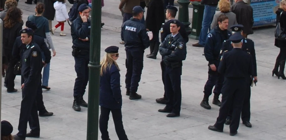 several police officers are gathered outside a busy intersection