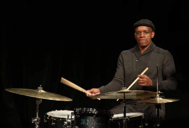 a man playing drums on top of a drum set