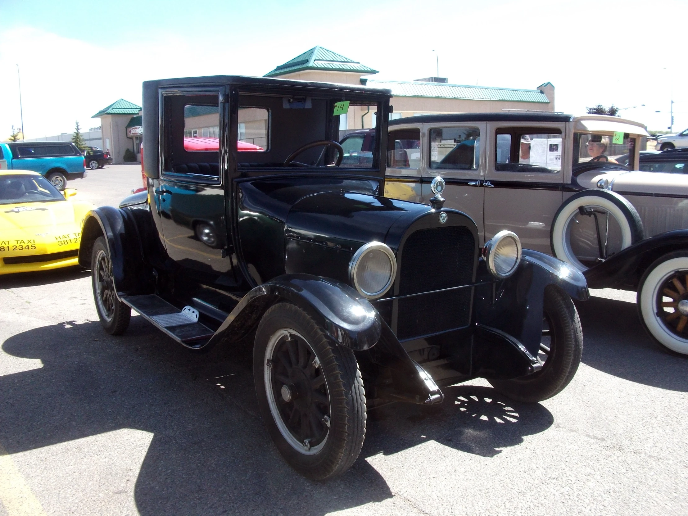 antique model cars sitting in a parking lot