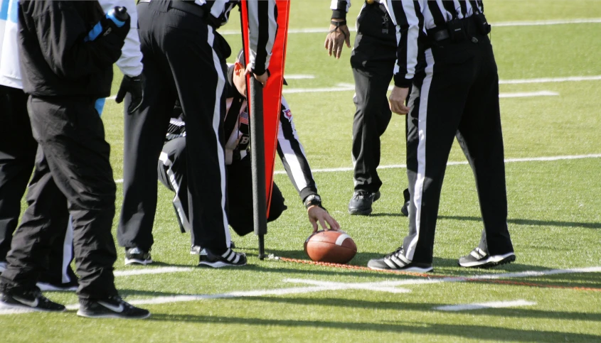 several referees standing on a field with a ball