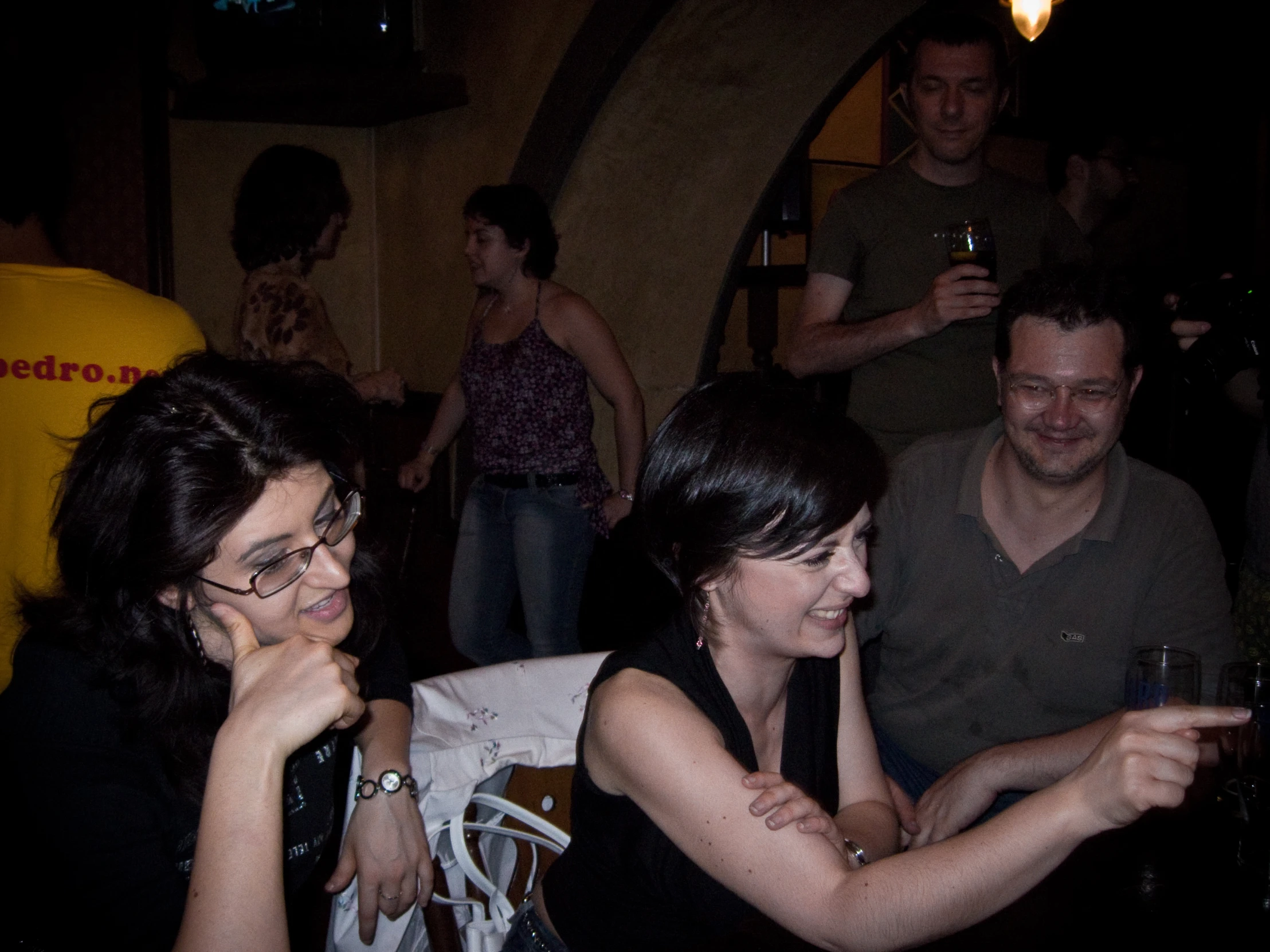 three friends laughing while looking at their cell phones