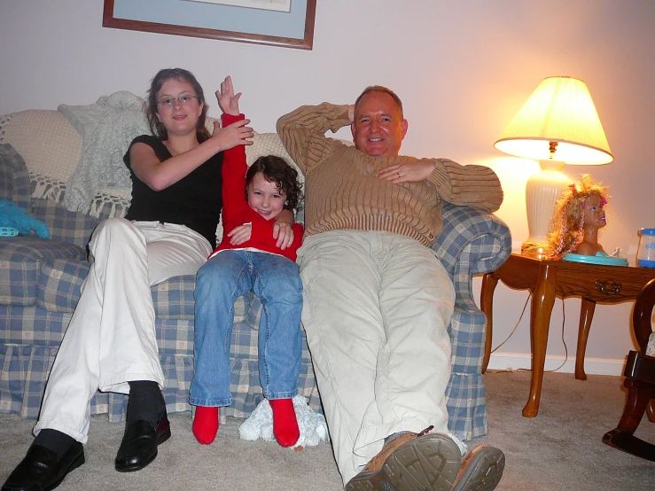 two adults and two children sit on the couch