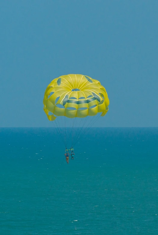 people parasailing with a big green sail in the distance