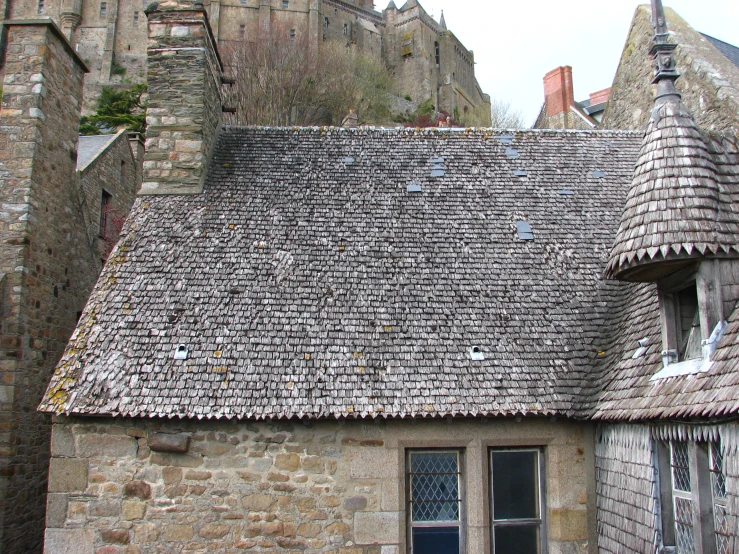 a brick building with a small window and a brown tile roof