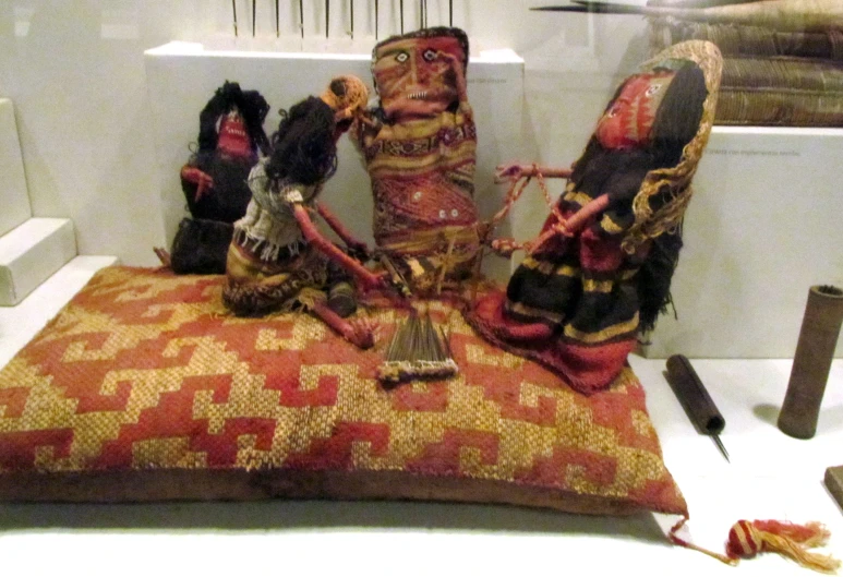 a couple of dolls on a pillow next to some other stuff