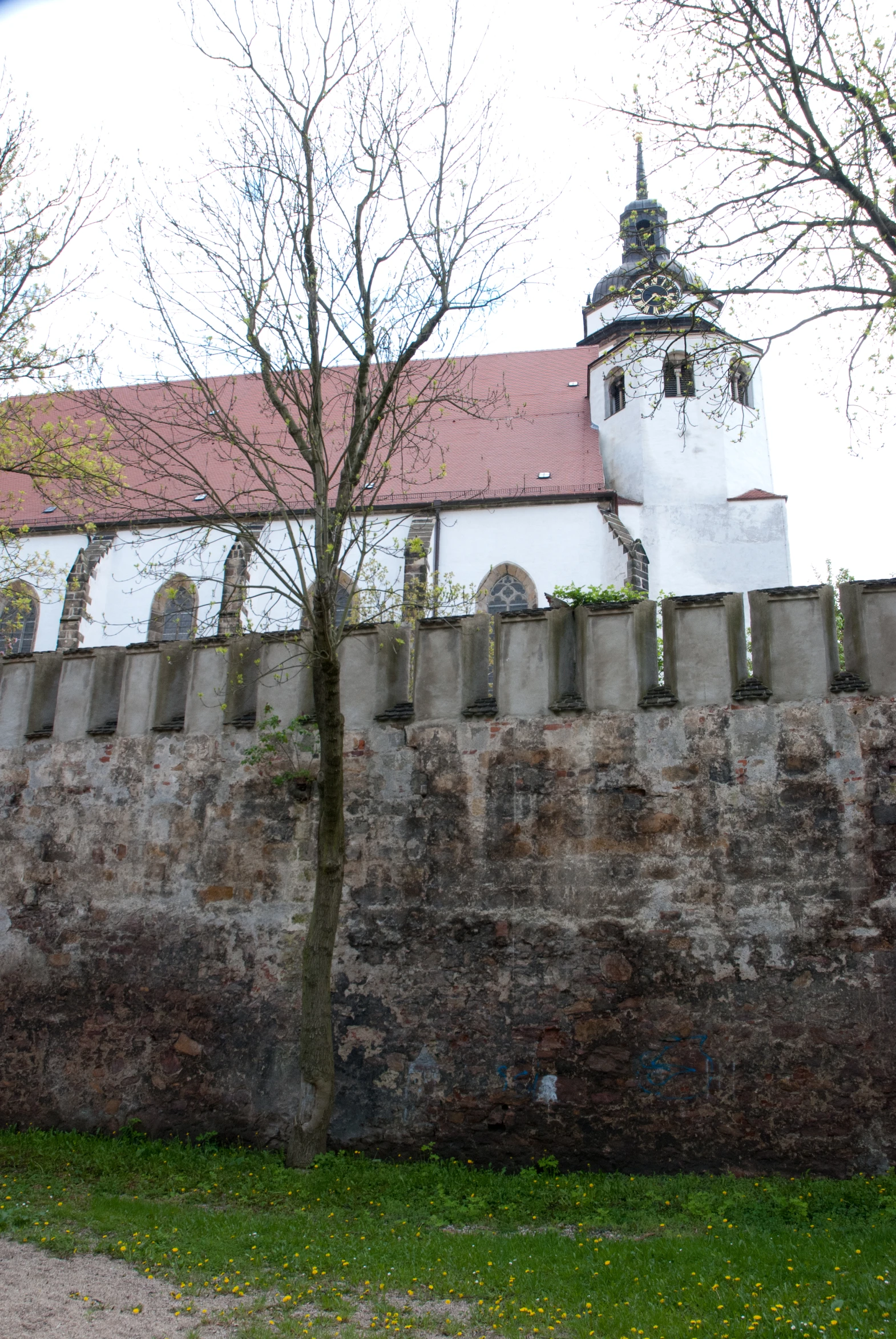 this is a stone wall with an old church behind it