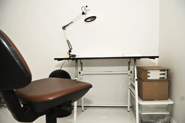 the chair sits in front of a computer desk with lamp on top