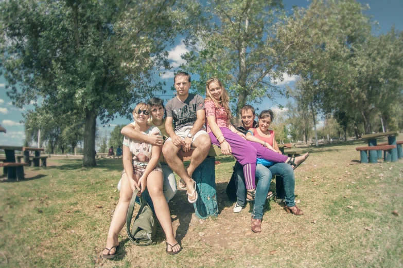 four people posing for a picture in a park