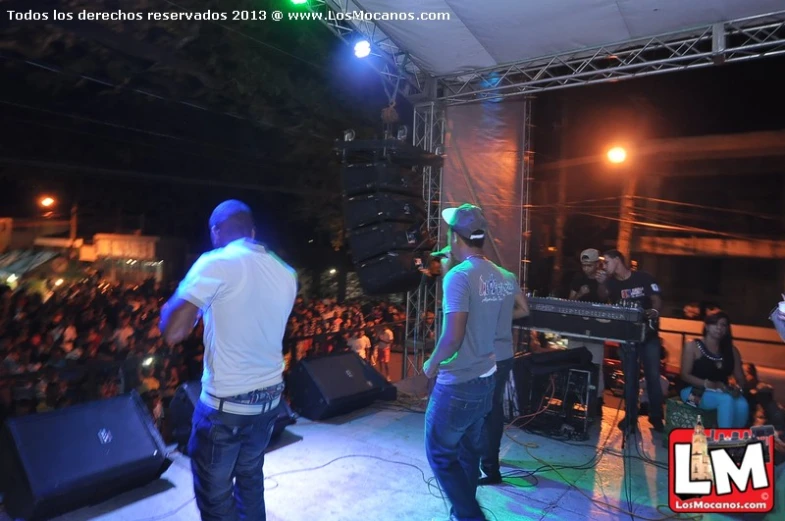 group of men standing on stage with an audience