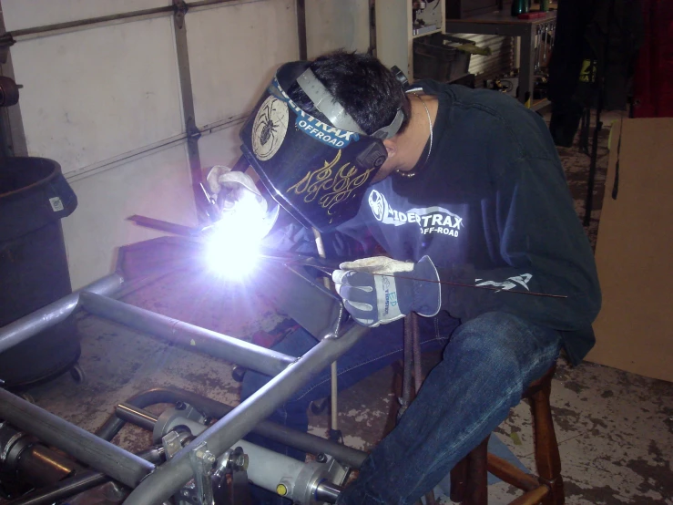 a man in his workshop weldering metal with a torch