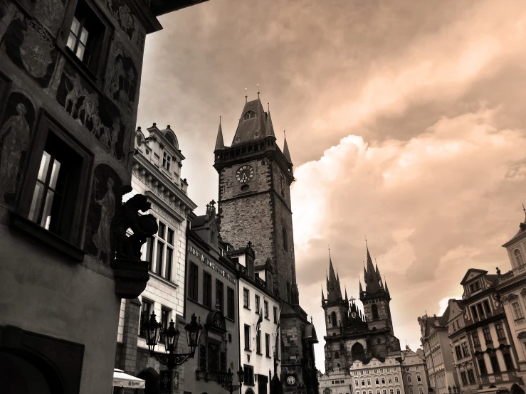 some buildings with towers against a cloudy sky