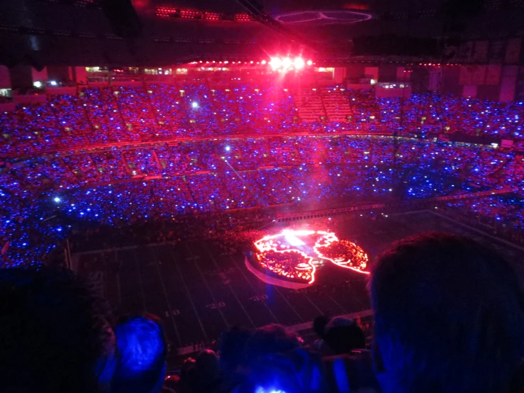 large room with red and blue lights and people in seats