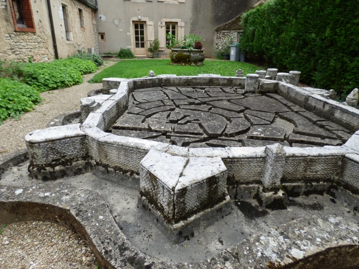 a sculpture in an old stone garden setting