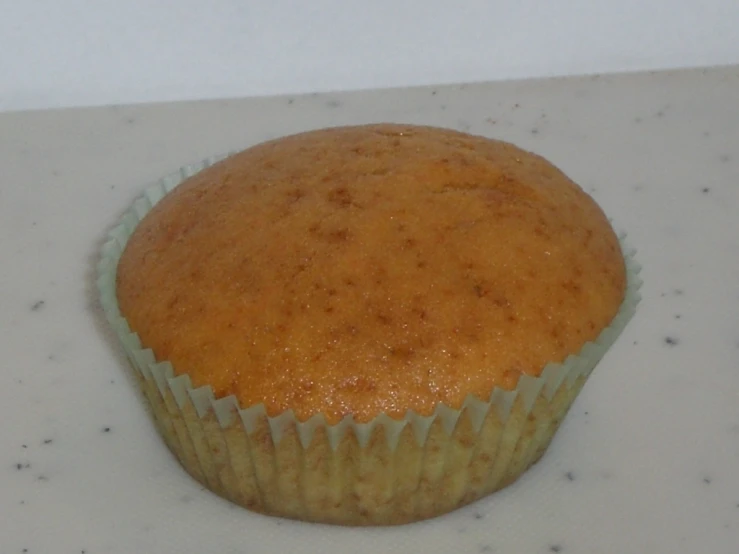 a single cupcake sitting on a white counter