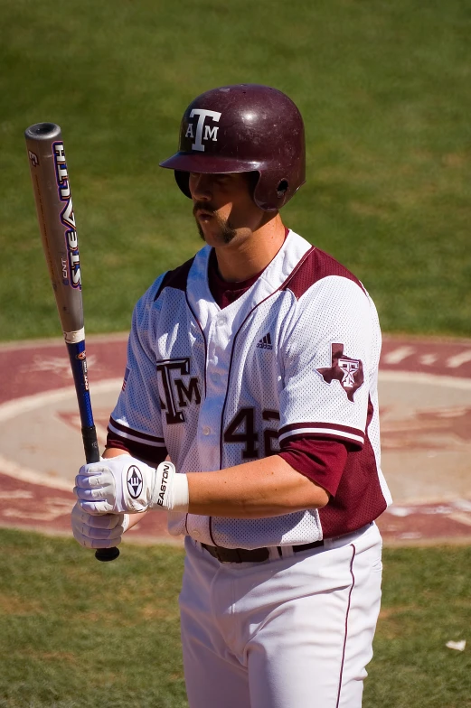 a man is carrying a baseball bat on the field