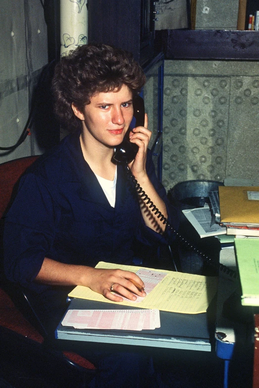 a person on a telephone call in a messy room