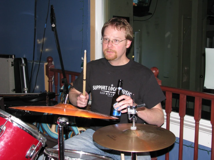 a man that is playing some drums and sitting down