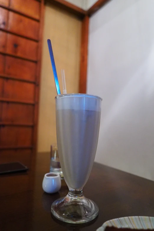 a glass with a milkshake and a spoon