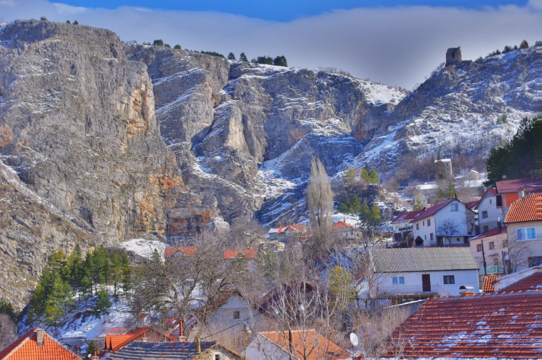 a town is surrounded by mountains and snow covered buildings