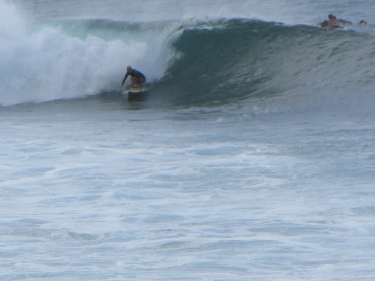 a man riding on top of a wave on a surfboard