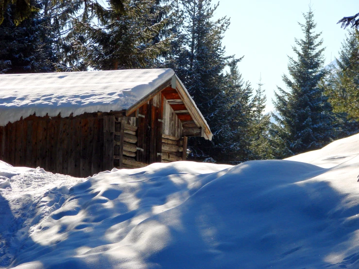 small wooden structure at the top of snowy slope