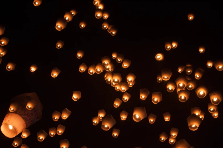 the sky full of lanterns are lit up in the dark