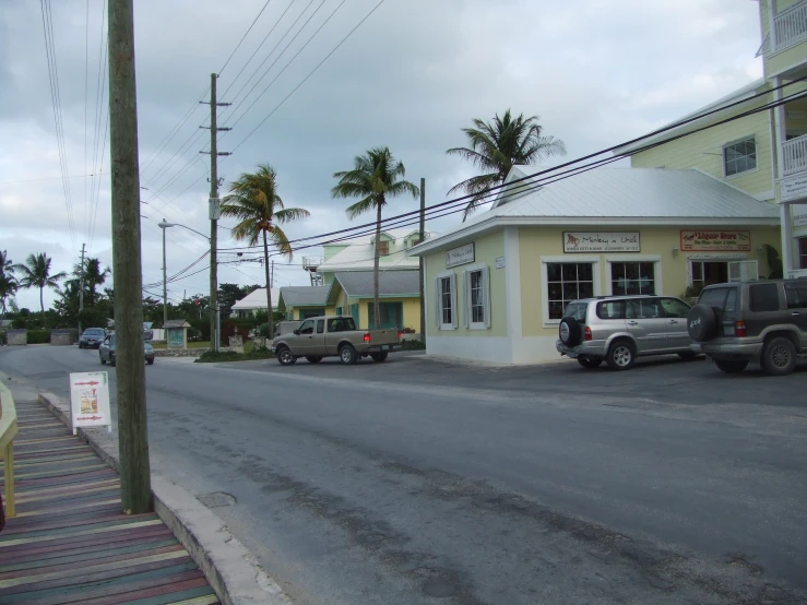 several vehicles driving down a city street next to buildings