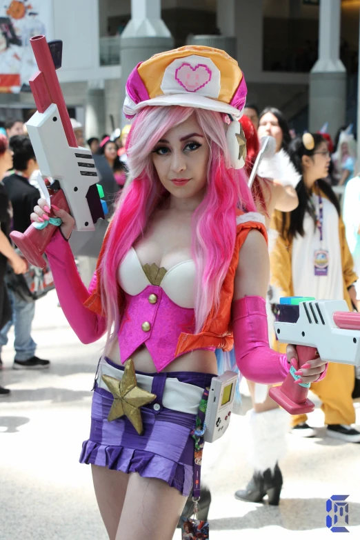 female model in colorful outfit with pink hair with gun