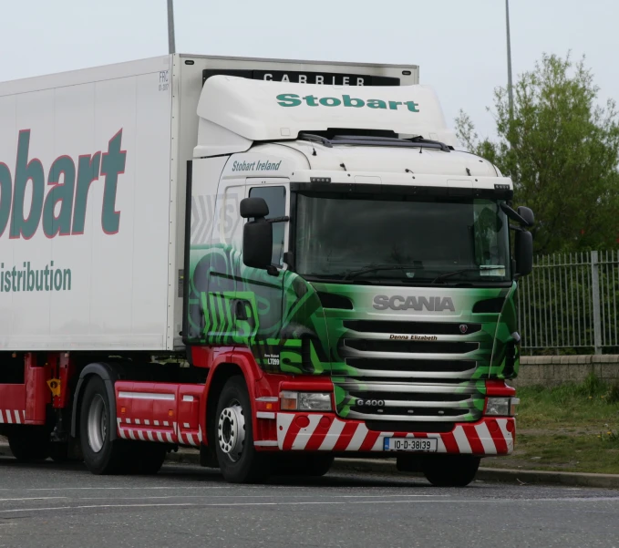 large, well decorated tractor truck driving on street next to fence