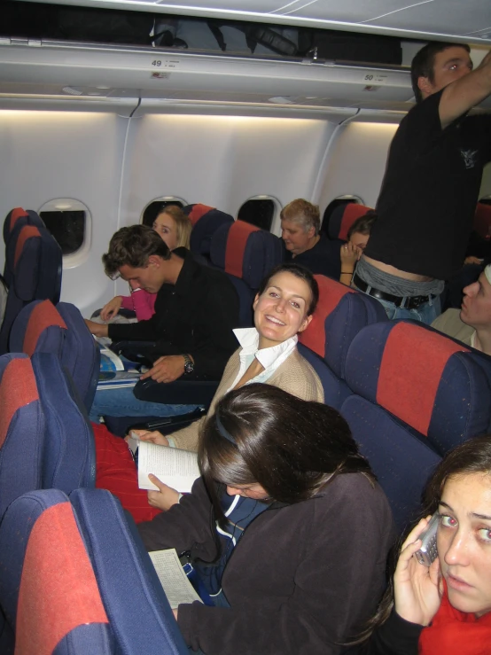 some people sit inside an airplane on their phones